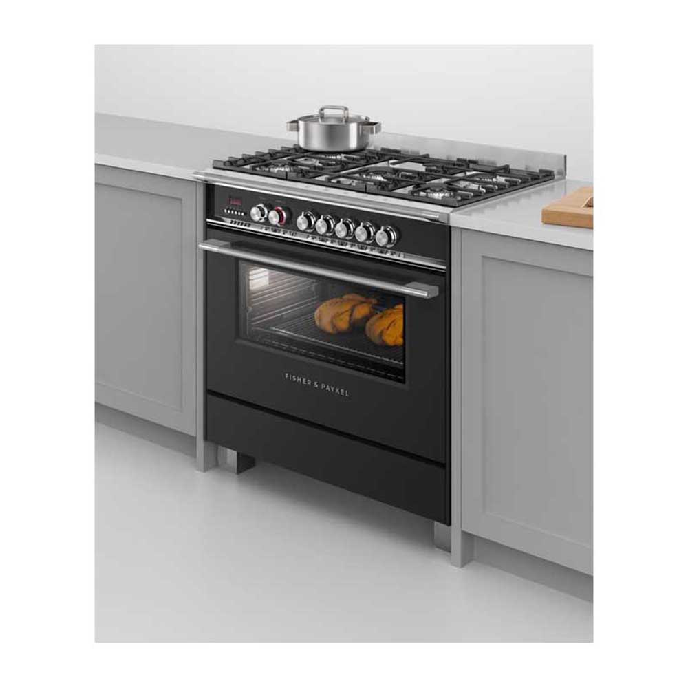 Fisher and Paykel OR90SCG4B1 90cm Dual Fuel Freestanding Cooker, Front left view with food in oven and cooking dish on cooktop